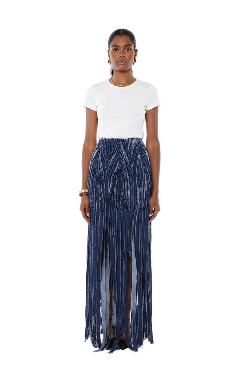 Woman wearing a white top and blue pleated skirt on a white background