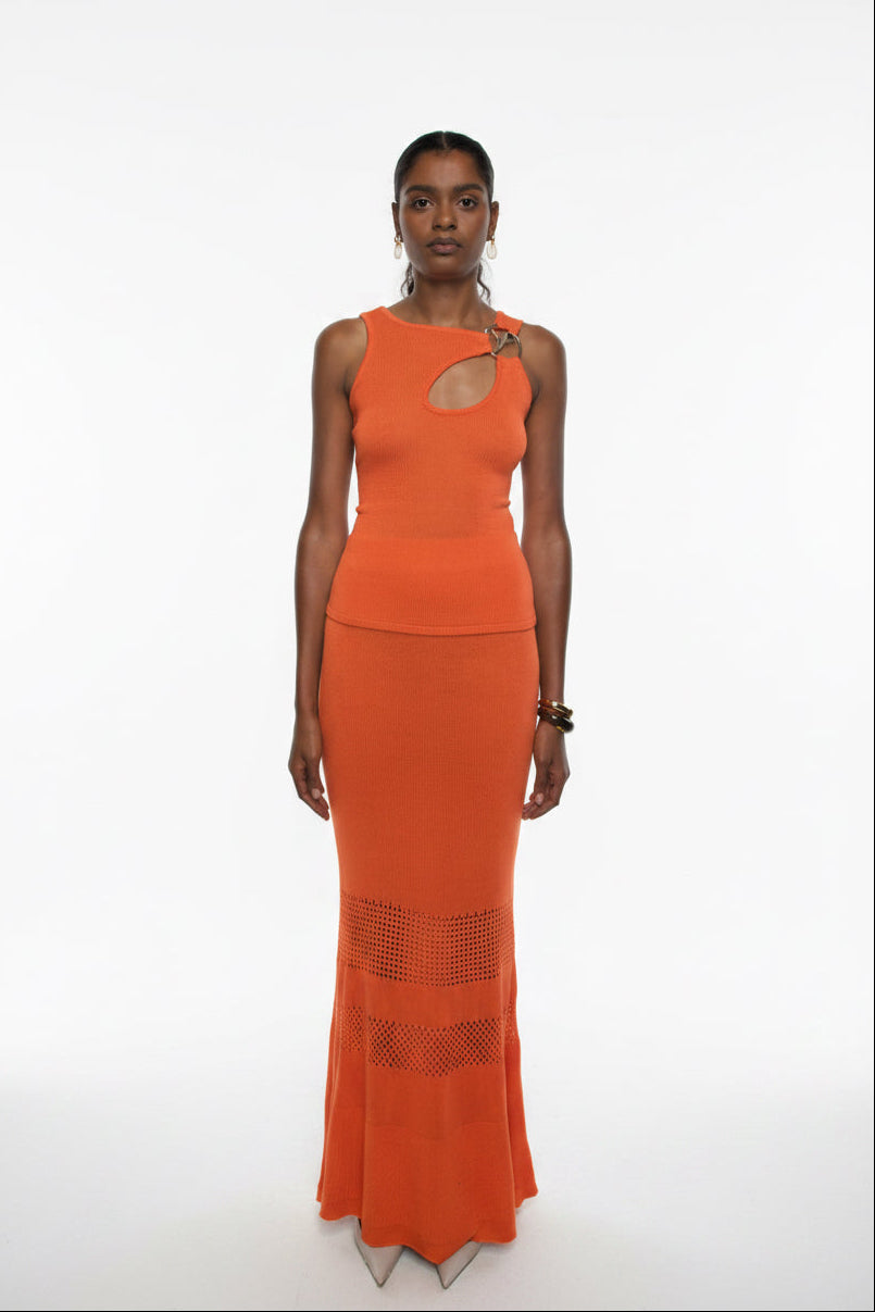 Woman wearing an orange dress with cut-out design on a white background